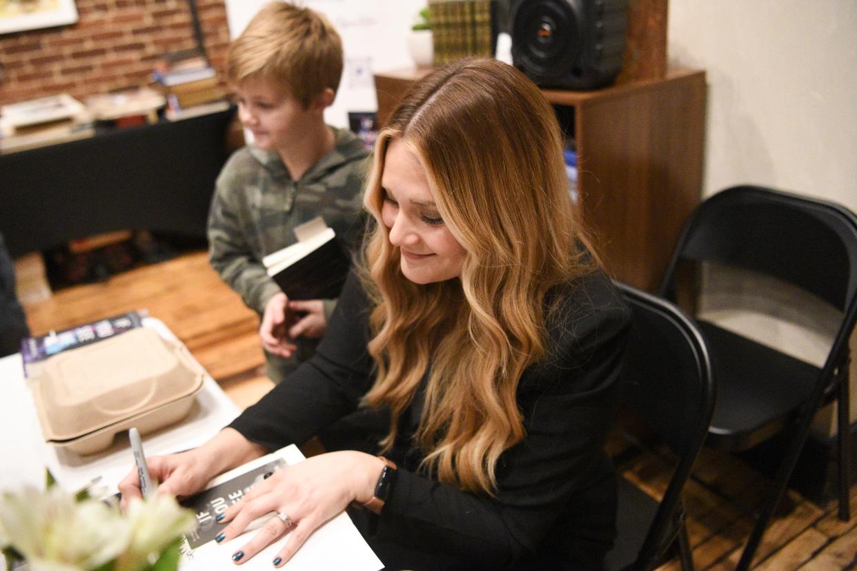 Author Audra McElyea signs a copy of her book ‘If You See Me’ at her book launch at Addison’s Bookstore on Gay Street, Friday, Jan. 5, 2024.