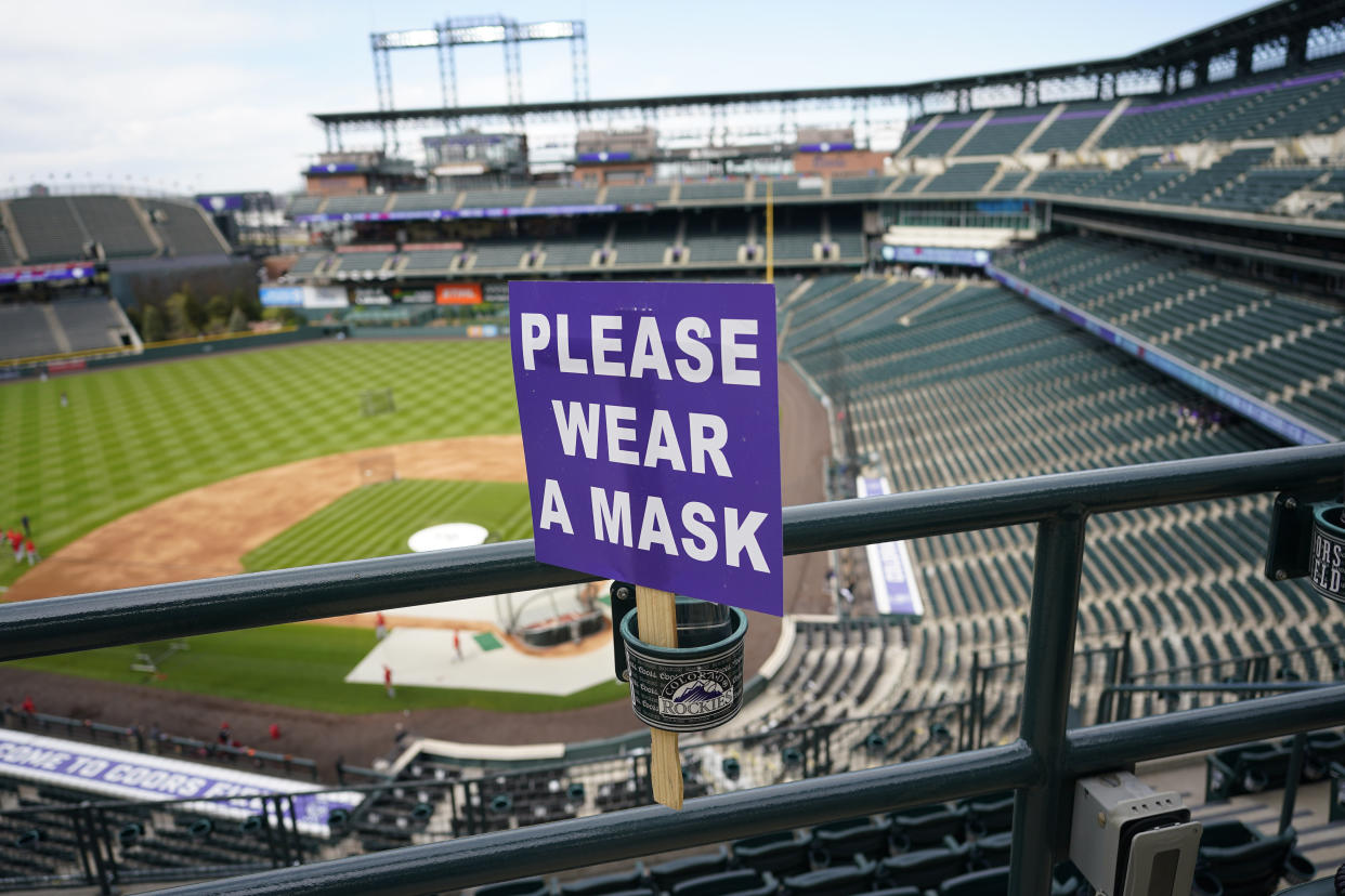 A COVID-19 sign urging fans to wear their masks is threaded through a drink holder in the upper deck of Coors Field before the Colorado Rockies host the Cincinnati Reds in a baseball game late Thursday, May 13, 2021, in Denver. (David Zalubowski/AP)

















