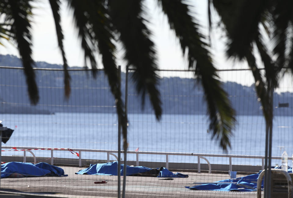 FILE - Bodies of victims covered by sheets at the scene of a truck attack in Nice, southern France, Friday, July 15, 2016. Eight people go on trial Monday Sept.5, 2022 in a special French terrorism court for alleged roles in helping the attacker who drove a truck into the Nice beachfront on Bastille Day 2016, killing 86 people. (AP Photo/Luca Bruno, File)