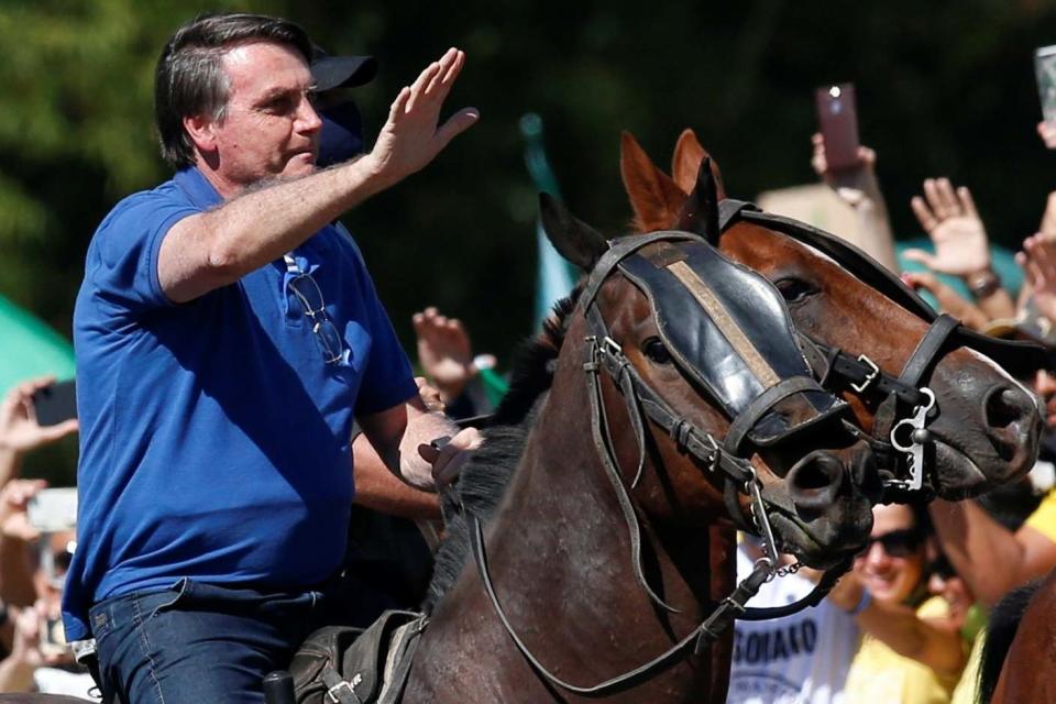 Brazil's President Jair Bolsonaro rides a horse during a meeting with supporters protesting in his favour (REUTERS)