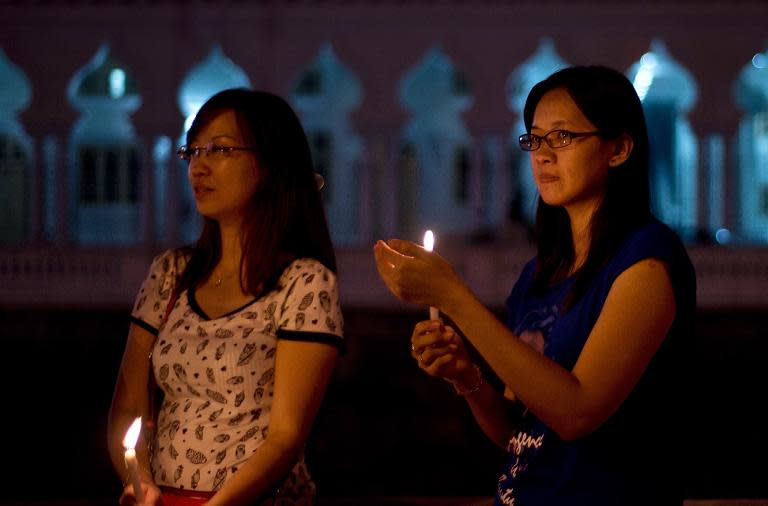 Malaysian ethnic Chinese participants take part in a vigil for missing Malaysia Airlines passengers at the Independence Square in Kuala Lumpur on March 10, 2014