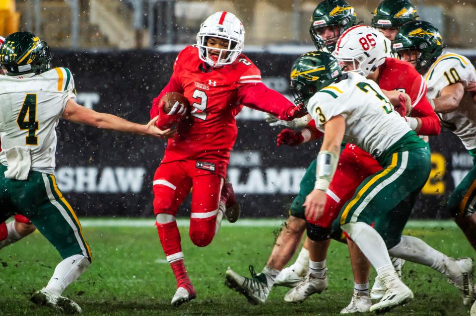 Moon's Jeremiah Dean plows through Penn-Trafford defenders in the first quarter of the WPIAL 5A Championship Saturday at Heinz Field.[Lucy Schaly/For BCT]