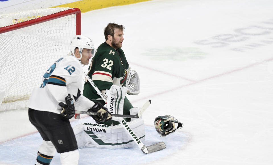 Minnesota Wild goalie Alex Stalock loses in mask as San Jose Sharks' Patrick Marieau, left, looks for the pass in the third period of an NHL hockey game, Saturday, Feb. 15, 2020, in St. Paul, Minn. San Jose won 2-0.(AP Photo/Tom Olmscheid)