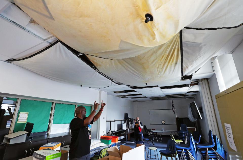 Teacher Eric Mathews points out water damage in a North High classroom Saturday.