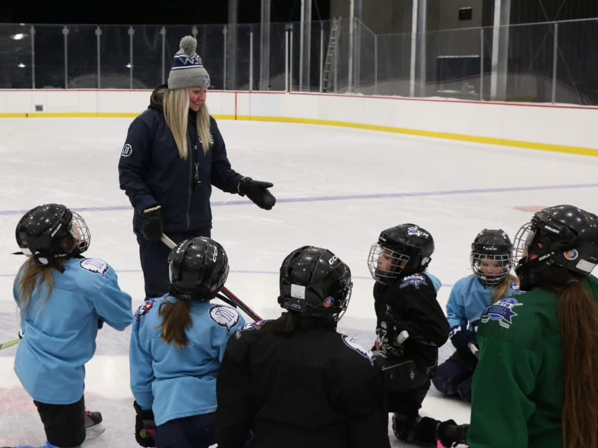 Janelle Forcand is shown coaching the U11 female Winnipeg Jets Hockey Academy team. She has won provincial and national community coaching awards and now works with Hockey Winnipeg to make hockey more accessible, diverse and safe for new players.  (Nicole McAlpine/True North Youth Foundation - image credit)