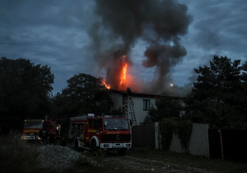 Ukrainian firefighters put out a fire in a residential house after a Russian military strike in Kharkiv