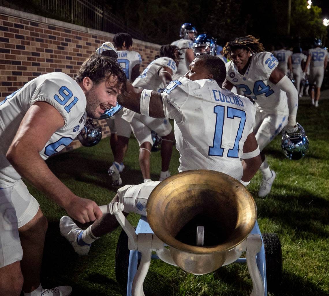 North Carolina kicker Ben Kieran (91) rings the victory bell as teammate Chris Collins (17) rides off the field to the locker room following the Tar Heels 38-35 victory over Duke on Saturday, October 15, 2022 at Wallace-Wade Stadium in Durham, N.C.