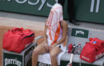 Romania's Mihaela Buzarnescu sits under her towel during a change of ends as she plays against United States Serena Williams during their second round match on day four of the French Open tennis tournament at Roland Garros in Paris, France, Wednesday, June 2, 2021. (AP Photo/Thibault Camus)