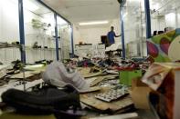 A man stands inside a store that was looted during a police strike in Salvador, Bahia state, April 17, 2014. REUTERS/Valter Pontes