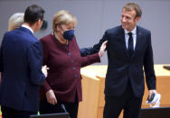 French President Emmanuel Macron, right, speaks with German Chancellor Angela Merkel, center right, as European Commission President Ursula von der Leyen, left, speaks with Poland's Prime Minister Mateusz Morawiecki during a round table meeting at an EU summit in Brussels, Friday, Oct. 22, 2021. European Union leaders conclude a two-day summit on Friday in which they discussed issues such as climate change, the energy crisis, COVID-19 developments and migration.(AP Photo/Olivier Matthys, Pool)