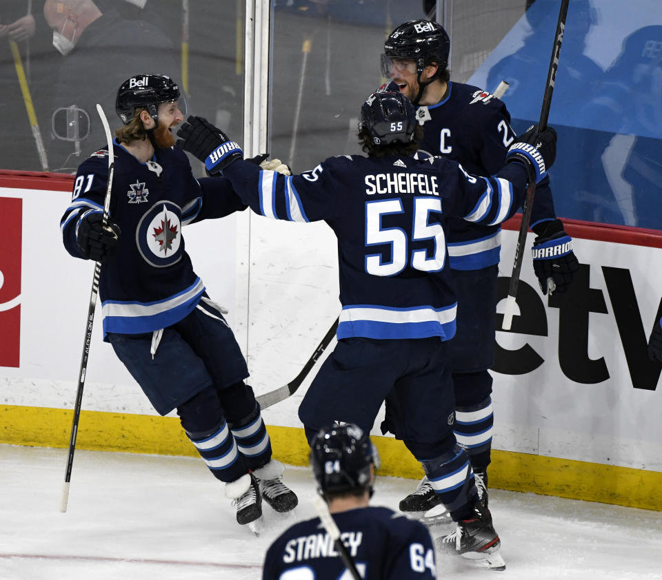 Winnipeg Jets' Blake Wheeler (26) celebrates his goal against the Vancouver Canucks with Kyle Connor (81) and Mark Scheifele (55) during the third period of an NHL hockey game Tuesday, May 11, 2021, in Winnipeg, Manitoba. (Fred Greenslade/The Canadian Press via AP)