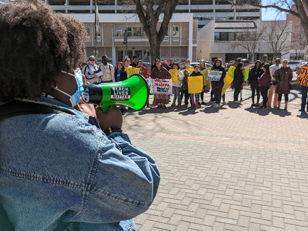 Dozens of demonstrators gathered at Saskatoon City Hall on Saturday afternoon before marching through downtown as they called for accountability and justice in the death of Hodan Hashi, 23.  (Dayne Patterson/CBC - image credit)