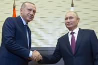 Russian President Vladimir Putin, right, and Turkish President Recep Tayyip Erdogan shake hands during their meeting in the Bocharov Ruchei residence in the Black Sea resort of Sochi in Sochi, Russia, Monday, Sept. 17, 2018. The presidents of Russia and Turkey are meeting in the Russian Black Sea resort of Sochi on Monday in a bid to find a diplomatic resolution to the crisis around a rebel-held region in Syria. (AP Photo/Alexander Zemlianichenko, Pool)
