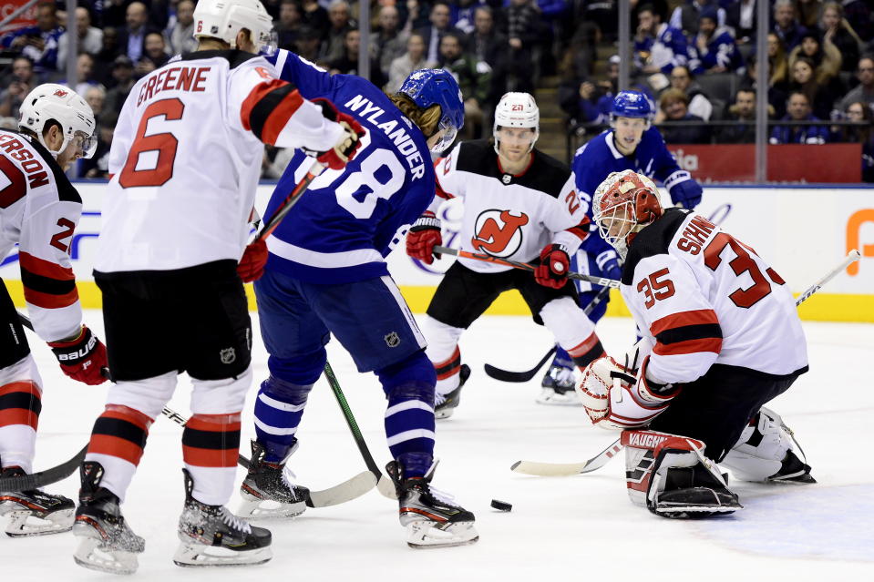 New Jersey Devils goaltender Cory Schneider (35) keeps his eye on a loose puck as Maple Leafs right wing William Nylander (88) looks for the shot under pressure from New Jersey Devils' Andy Greene (6), Damon Severson (28) and Blake Coleman (20) during the second period of an NHL hockey game Tuesday, Jan. 14, 2020, in Toronto. (Frank Gunn/The Canadian Press via AP)