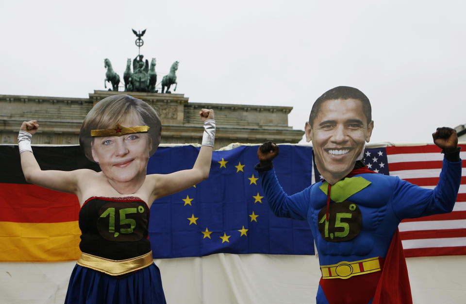 FILE - In this June 26, 2009 file photo, climate activists dressed as super heroes German chancellor Angela Merkel, left, and U.S. President Barack Obama, right, pose in front of Brandenburg gate in Berlin, Germany. Angela Merkel has just about seen it all when it comes to U.S. presidents. Merkel on Thursday makes her first visit to the White House since Joe Biden took office. He is the fourth American president of her nearly 16-year tenure as German chancellor. (AP Photo/Maya Hitij, File)