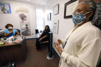 Clinician and social worker Lisa Williams, right, speaks in front of, Chinnika Crisler, left, and Kim Tate, center, Aug. 14, 2020, at the Community Health Care Center on the campus of Tougaloo College in Tougaloo, Miss. Williams said although the coronavirus pandemic has made a lot of the issues that patients deal with worse, they aren't anything new. “People have been struggling for a long, long time," she said. (AP Photo/Rogelio V. Solis)