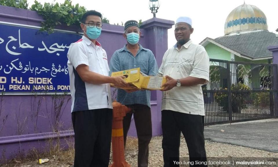 Pekan Nanas assemblyperson Yeo Tung Siong distributing aid.