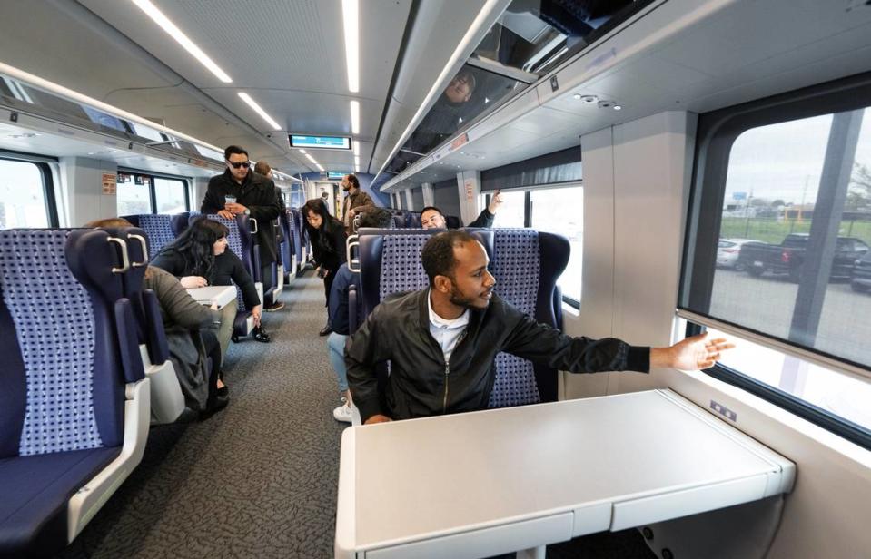 D'Mitri Williams ajusta la persiana de la ventana del nuevo vagón de pasajeros Venture de Amtrak para su línea San Joaquins durante una presentación en las instalaciones de mantenimiento ferroviario ACE en Stockton, California, el martes 5 de marzo de 2024.