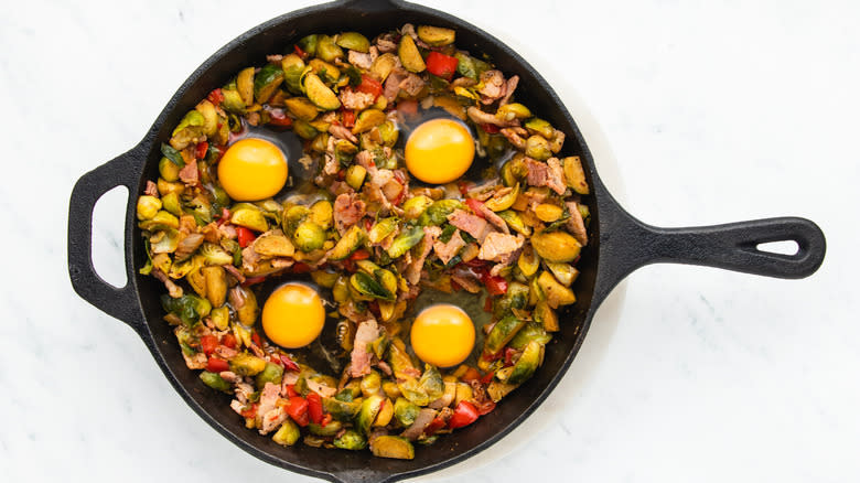 Eggs cracked into Brussels sprouts hash