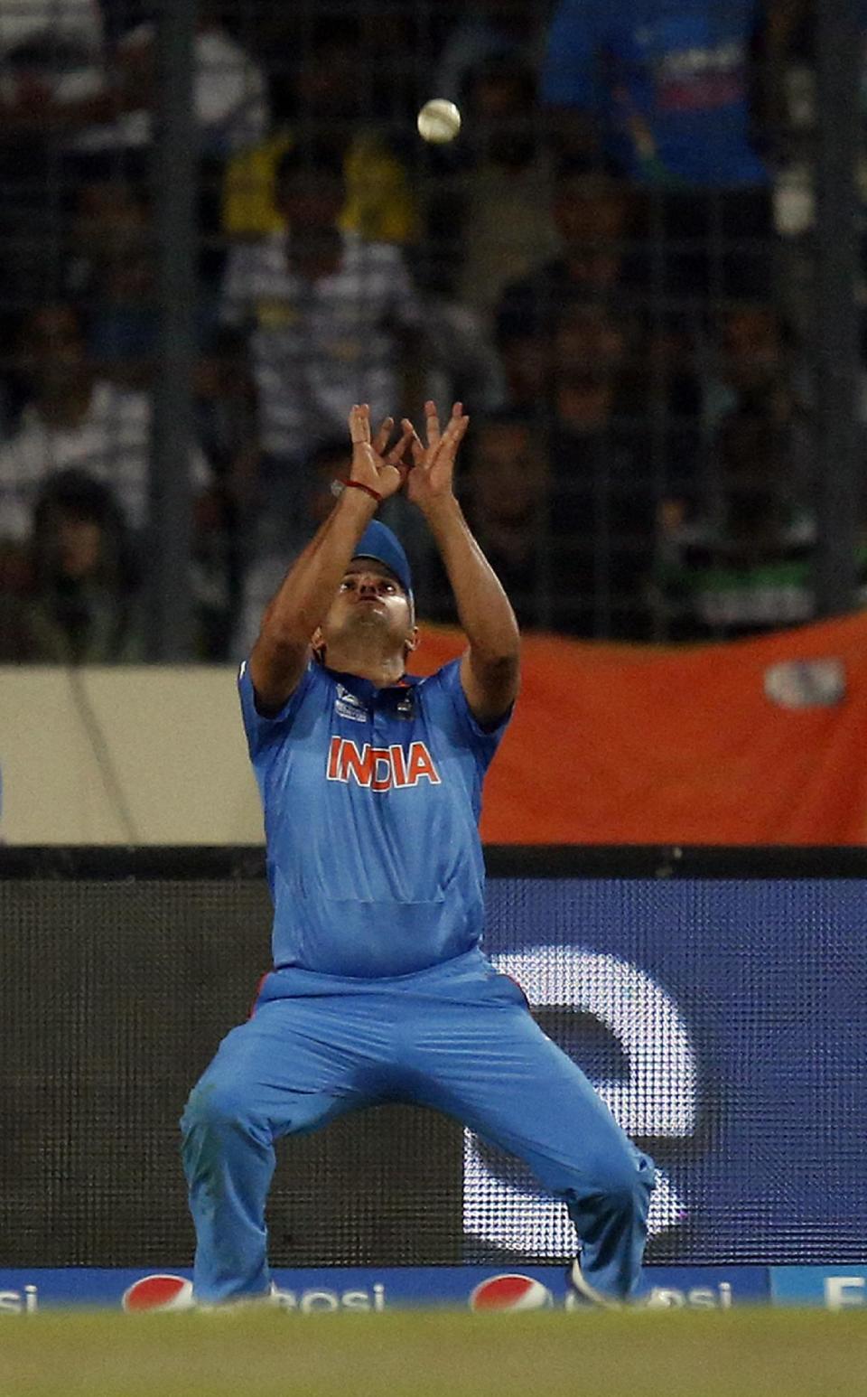 India's Suresh Raina prepares to take the catch to dismiss Pakistan's Umar Akmal during their ICC Twenty20 Cricket World Cup match in Dhaka, Bangladesh, Friday, March 21, 2014. (AP Photo/Aijaz Rahi)