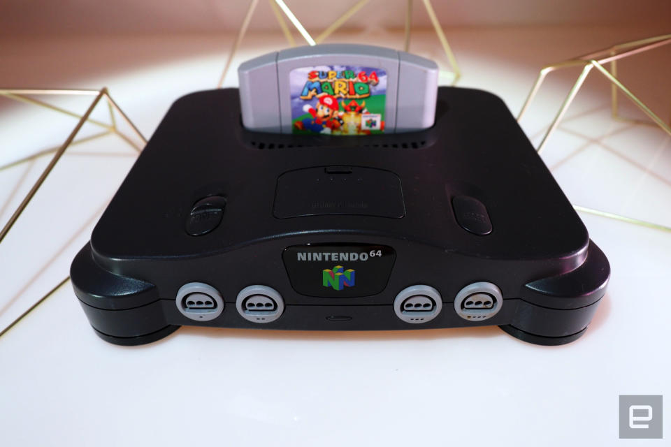 <p>Nintendo 64 on a white table with games</p>
