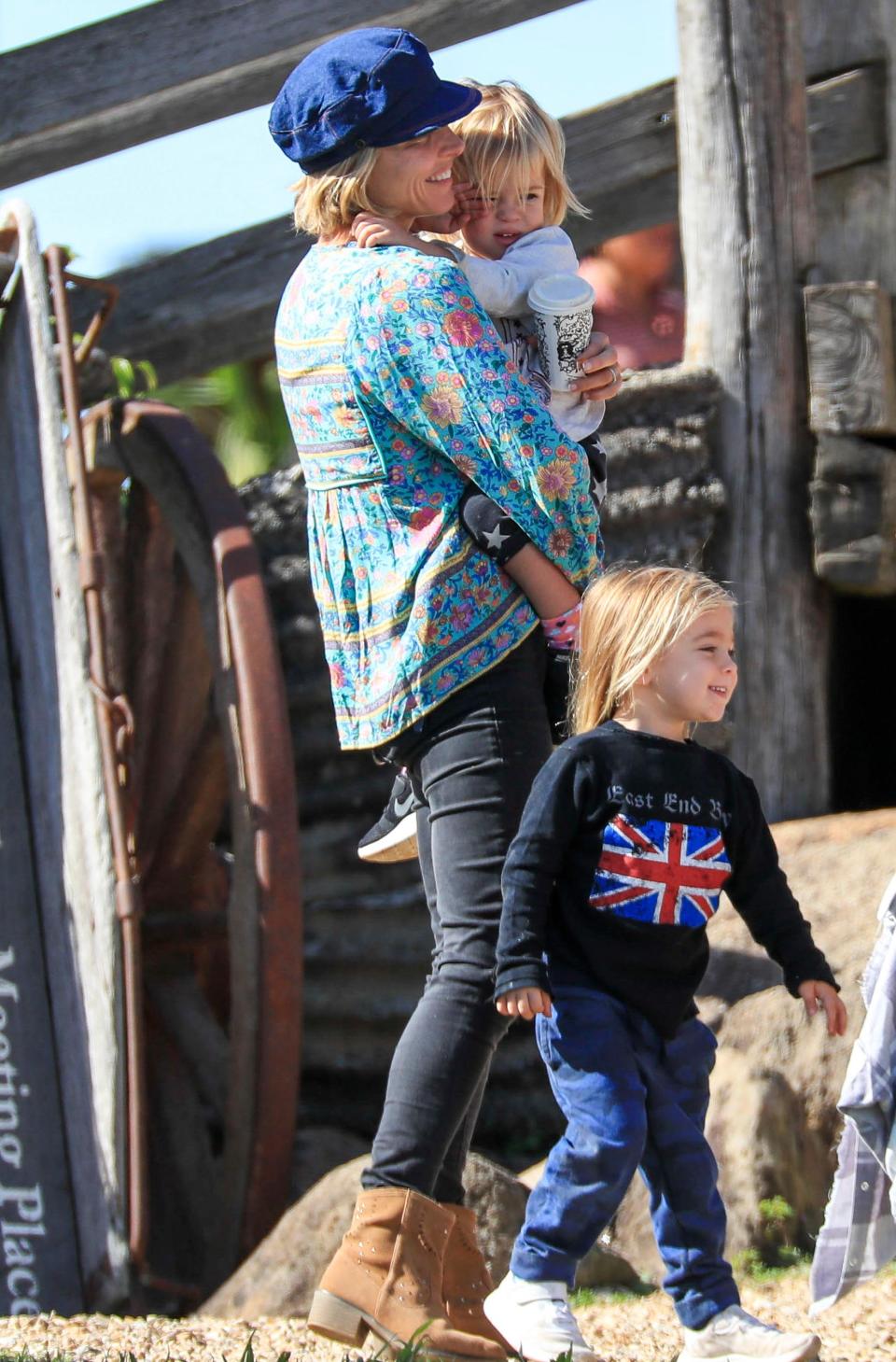 Elsa looked comfy in a turquoise floral top paired with black jeans, brown boots and a blue hat.