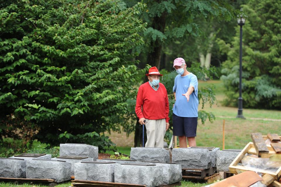 Earl Mills, of Mashpee, left, talks with Richard DeSorgher, a member of the Mashpee Historical Commission, as memorial stones were installed in 2020. Mills said he has been fighting to get the stones to honor the Mashpee Wampanoag Tribe soldiers.