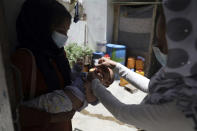 A health worker administers a vaccination to a child during a polio campaign in the old part of Kabul, Afghanistan, Tuesday, June 15, 2021. Gunmen on Tuesday targeted members of polio teams in eastern Afghanistan, killing a number of staffers, officials said. (AP Photo/Rahmat Gul)