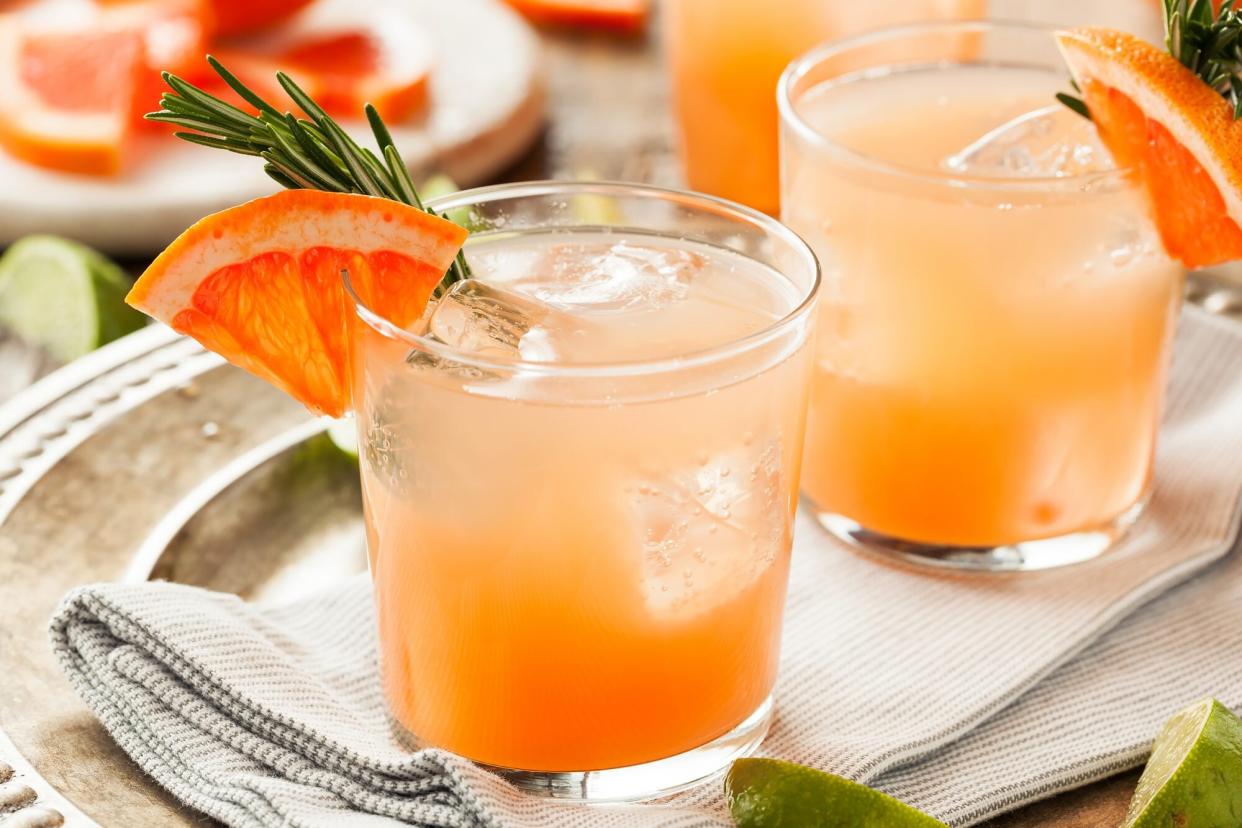 Glasses of refreshing Palomas with rosemary and grapefruit garnishes