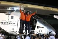 Pilots Andre Borschberg (L) and Bertrand Piccard celebrate after their arrival on Solar Impulse 2, a solar powered plane, at an airport in Abu Dhabi, United Arab Emirates July 26, 2016. REUTERS/Stringer