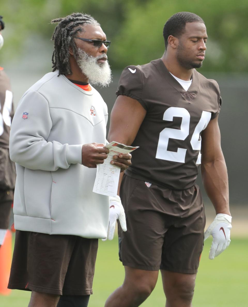 Cleveland Browns running backs coach Stump Mitchell and running back Nick Chubb keep an eye on OTA practice on May 25, 2022, in Berea.