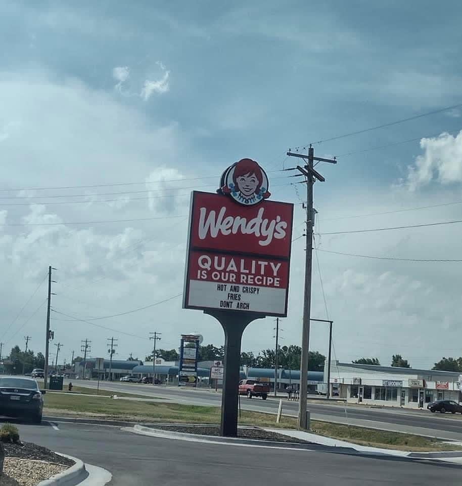 a Wendy's sign that says "hot and crispy fries don't arch"