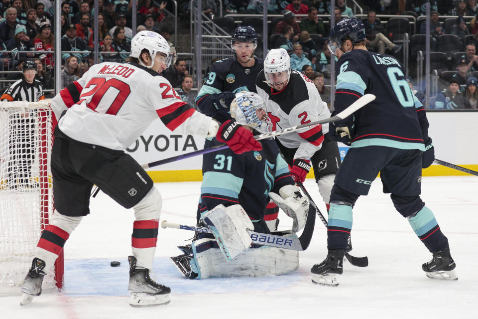 New Jersey Devils center Michael McLeod (20) reacts after a goal by Simon Nemec against Seattle Kraken goaltender Philipp Grubauer (31) during the second period of an NHL hockey game Thursday, Dec. 7, 2023, in Seattle. (AP Photo/Jason Redmond)