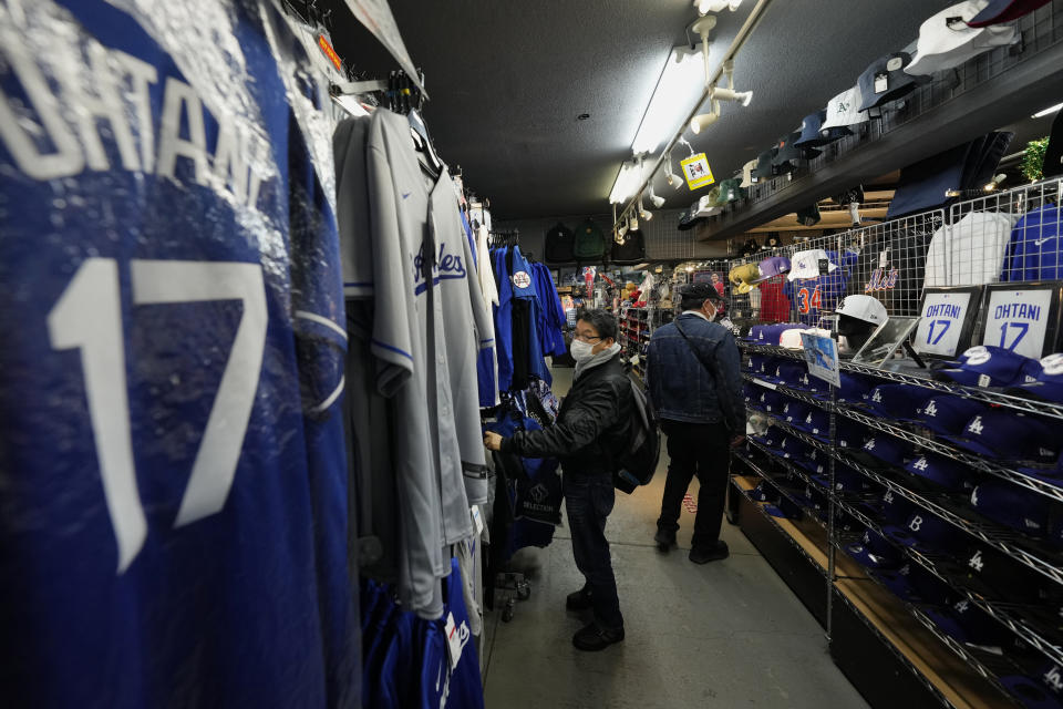 Customers shop for goods related to Shohei Ohtani of the Los Angeles Dodgers at SELECTION, a sporting goods store in Shinjuku district of Tokyo, Thursday, Feb. 29, 2024. (AP Photo/Hiro Komae)