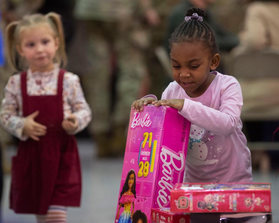 Eliana-May Taylor, 3, looks at the Barbie she received during First Lady Dr. Jill Biden and Santa’s visit at Ft. Campbell in Kentucky., Saturday, Dec. 23, 2023