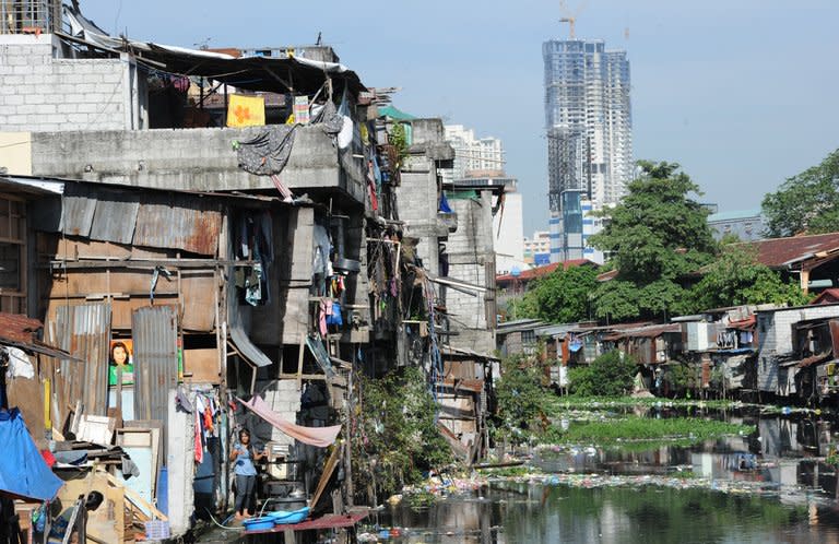 This picture taken on February 18, 2013 shows informal settlers' homes along a polluted waterway in Manila. Slum dwellers in Manila whose shanty homes choke the Pasig River and its tributaries have little choice but to live as if the national capital's most important waterway is clean