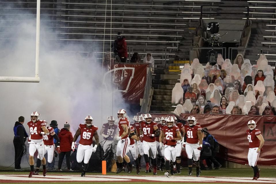 Wisconsin players are introduced with no fans in the stands before an NCAA college football game against Illinois Friday, Oct. 23, 2020, in Madison, Wis. (AP Photo/Morry Gash)