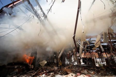 Firefighters try to extinuish fire at the community hall where Saudi-led warplanes struck a funeral in Sanaa, the capital of Yemen, October 9, 2016. REUTERS/Khaled Abdullah