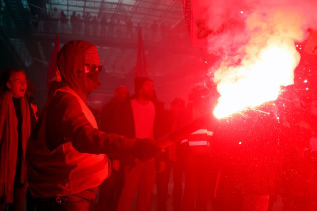 Striking railway workers hold red flares as they demonstrate against BlackRock.