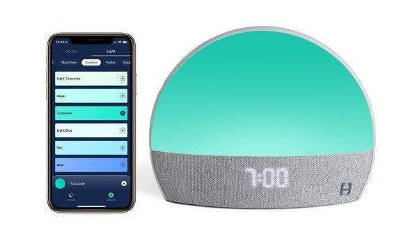 the Hatch machine with a turquoise light beside a smartphone open to the app