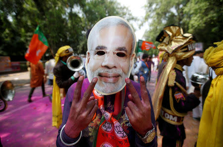 A supporter of Bharatiya Janata Party (BJP) celebrates after learning of the initial poll results outside the party headquarters in New Delhi, March 11, 2017. REUTERS/Adnan Abidi