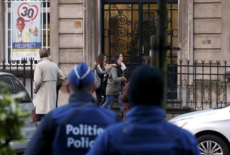 Belgian police officers stand guard outside a primary and secondary school in Brussels November 25, 2015. REUTERS/Francois Lenoir