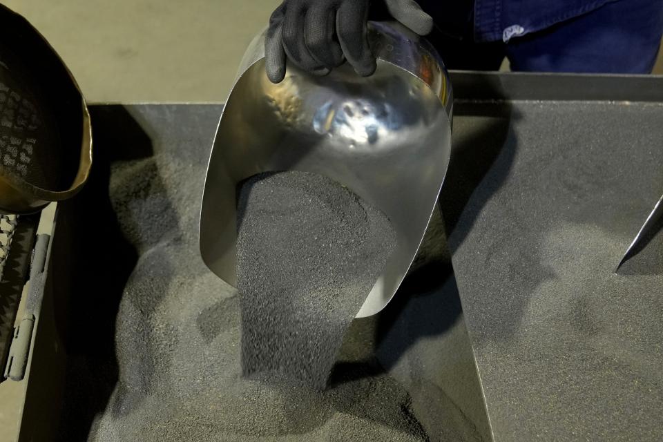 A worker shows sample of nickel matte at PT Vale Indonesia's processing plant in Sorowako, South Sulawesi, Indonesia, Tuesday, Sept. 12, 2023. Demand for critical minerals like nickel and cobalt is surging as climate change hastens a transition to renewable energy, boosting carbon emissions by miners and processors of such materials. (AP Photo/Dita Alangkara)