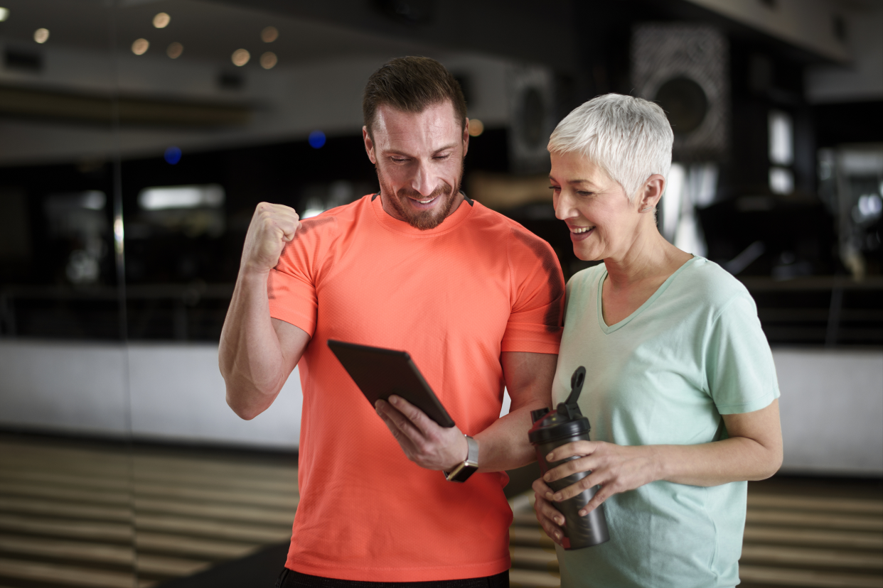 Personal trainer showing a senior woman his workout program