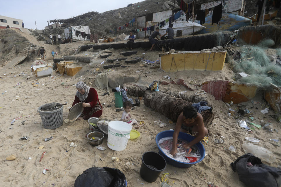 Palestinians resort to the sea water to bathe and clean their tools and clothes due the continuing water shortage in the Gaza Strip, on the beach of Deir al-Balah, Central Gaza Strip, Sunday, Oct. 29, 2023. (AP Photo/Mohammed Dahman)