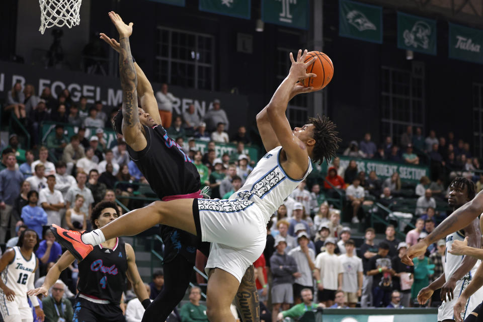 Tulane forward Collin Holloway, right, is fouled by Florida Atlantic guard Alijah Martin, left, during the second half of an NCAA college basketball game in New Orleans, Thursday, Jan. 11, 2024. (AP Photo/Tyler Kaufman)