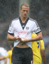 Fulham's Brede Hangeland wrings out his shirt during the Barclays Premier League match at Craven Cottage, London.