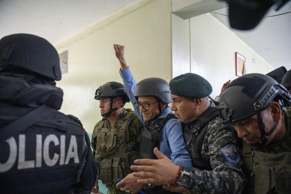 Security forces escort presidential candidate Christian Zurita, for "Movimiento Construye," after he voted in a snap election in Quito, Ecuador, Sunday, Aug. 20, 2023. Zurita's name was not on the ballot, but he substituted Villavicencio who was killed while at a campaign rally. (AP Photo/Carlos Noriega)
