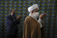 A cleric wearing a protective face mask to help prevent the spread of the coronavirus, leads the noon prayer at a mosque in the the city of Zanjan, some 330 kilometers (205 miles) west of the capital Tehran, Iran, Sunday, July 5, 2020. Iran on Sunday instituted mandatory mask-wearing as fears mount over newly spiking reported deaths from the coronavirus, even as its public increasingly shrugs off the danger of the COVID-19 illness it causes. (AP Photo/Vahid Salemi)