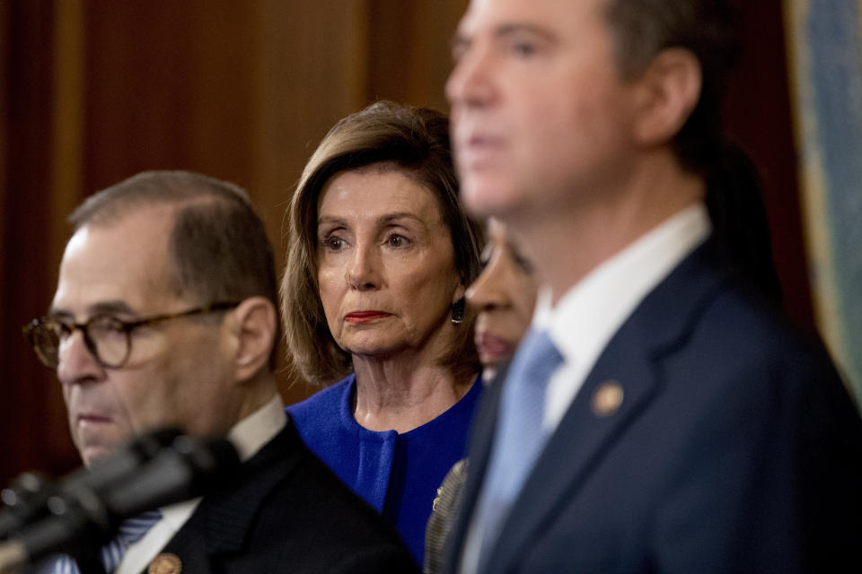 House Speaker Nancy Pelosi of Calif., center, and Chairman of the House Judiciary Committee Jerrold Nadler, D-N.Y., left, listen as Adam Schiff, D-Calif., Chairman of the House Intelligence Committee, foreground, speaks during a news conference to unveil articles of impeachment against President Donald Trump, abuse of power and obstruction of Congress, Tuesday, Dec. 10, 2019, on Capitol Hill in Washington. (AP Photo/Andrew Harnik)